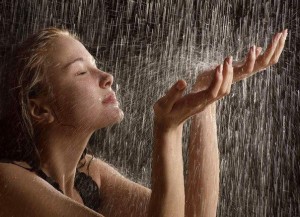 Девушка подставляет руки под струи дождя
